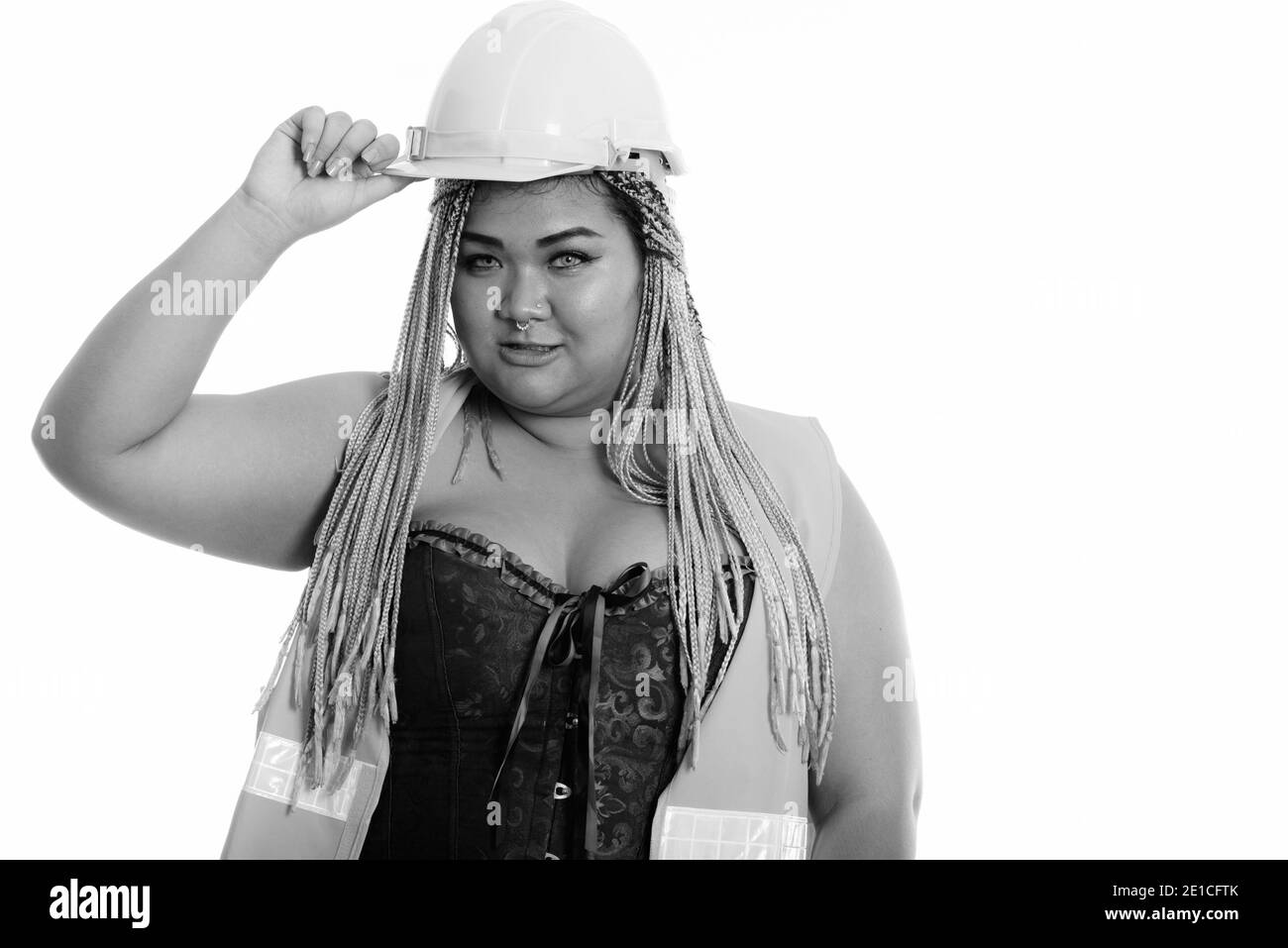 Young fat Asian construction woman holding safety helmet on head Stock Photo