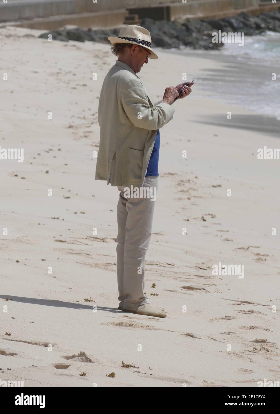 Man using his phone on the beach Stock Photo