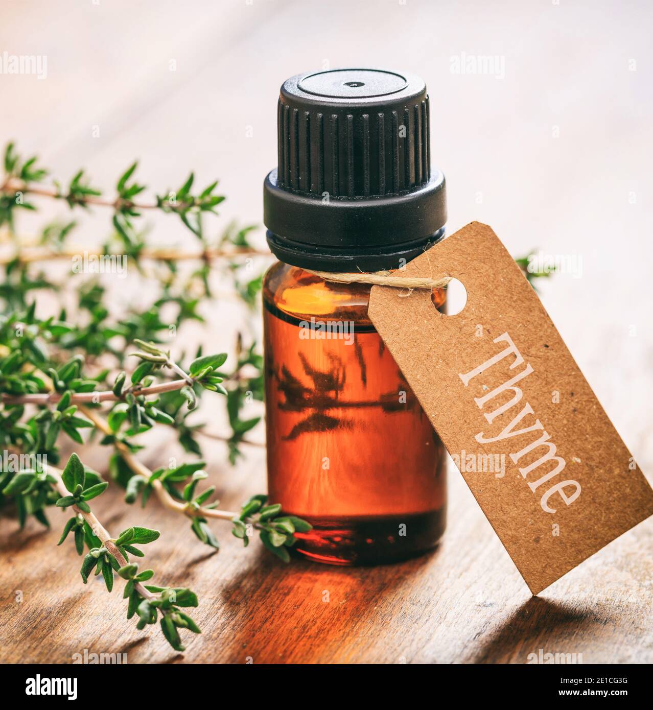 Fresh thyme plant leaves and essential oil on wooden background. Thymus aromatic perennial evergreen herb is a culinary herb used for cooking Stock Photo
