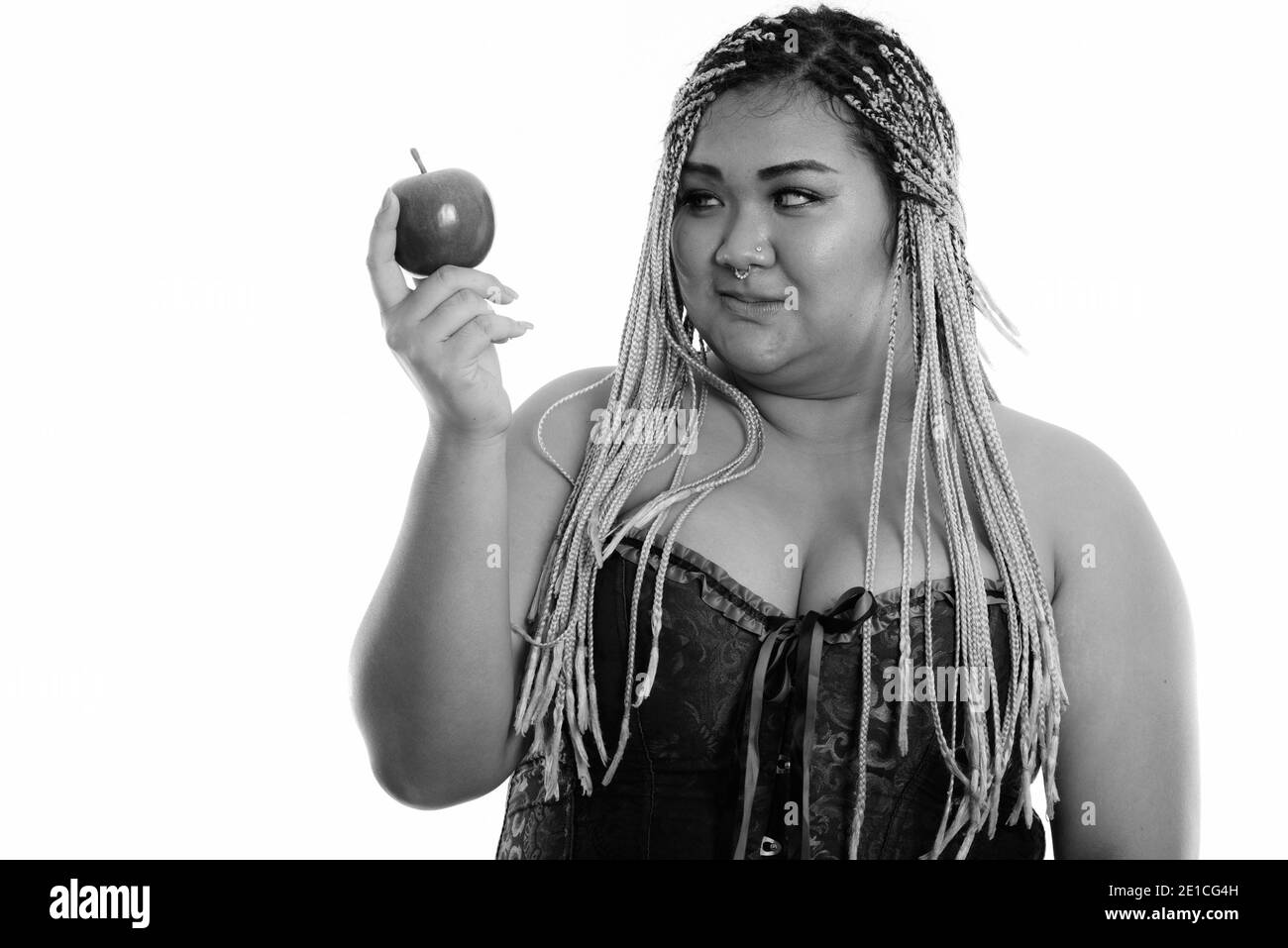 Young fat Asian woman holding and looking at red apple Stock Photo