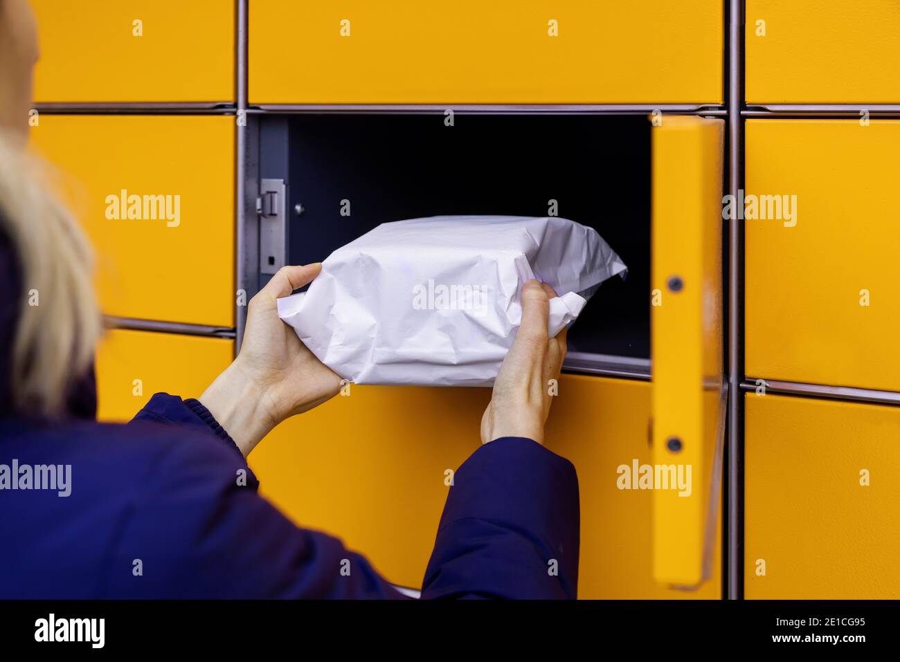 send or receive parcel with self service post terminal machine. hand with package Stock Photo