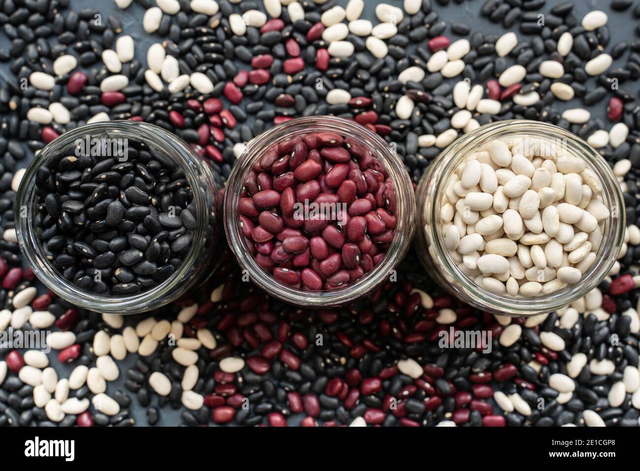 glass jar with black bean, red kidney bean and white bean. navy bean