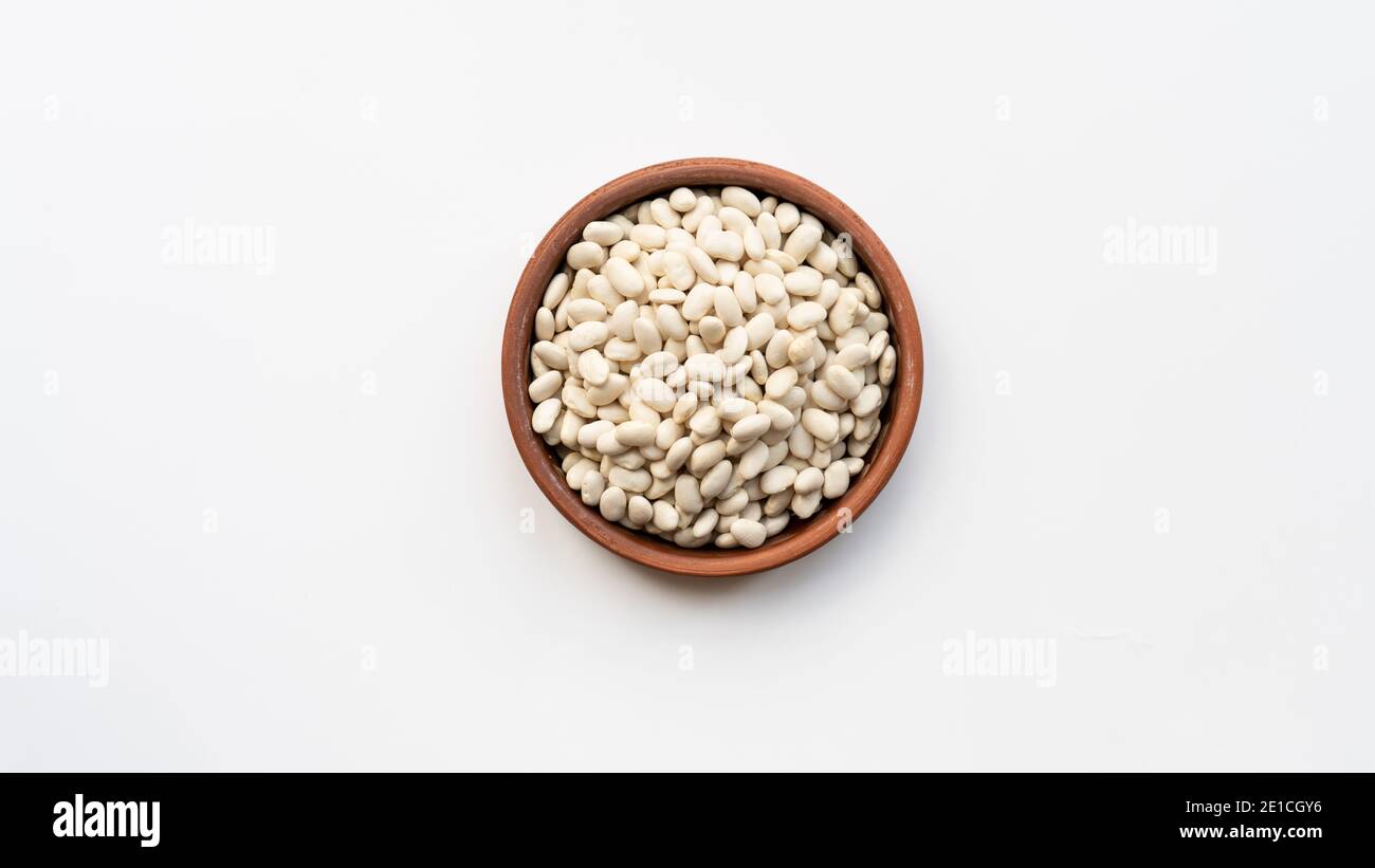 white beans in brown ceramic bowl. bowl of white kidney beans. navy, bean on white background isolated top view photo Stock Photo