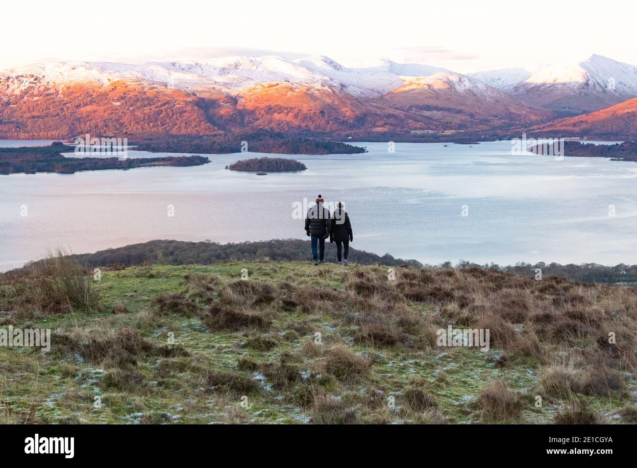 Loch Lomond - walkers enjoying a winter sunrise view from Conic Hill, Scotland, UK Stock Photo