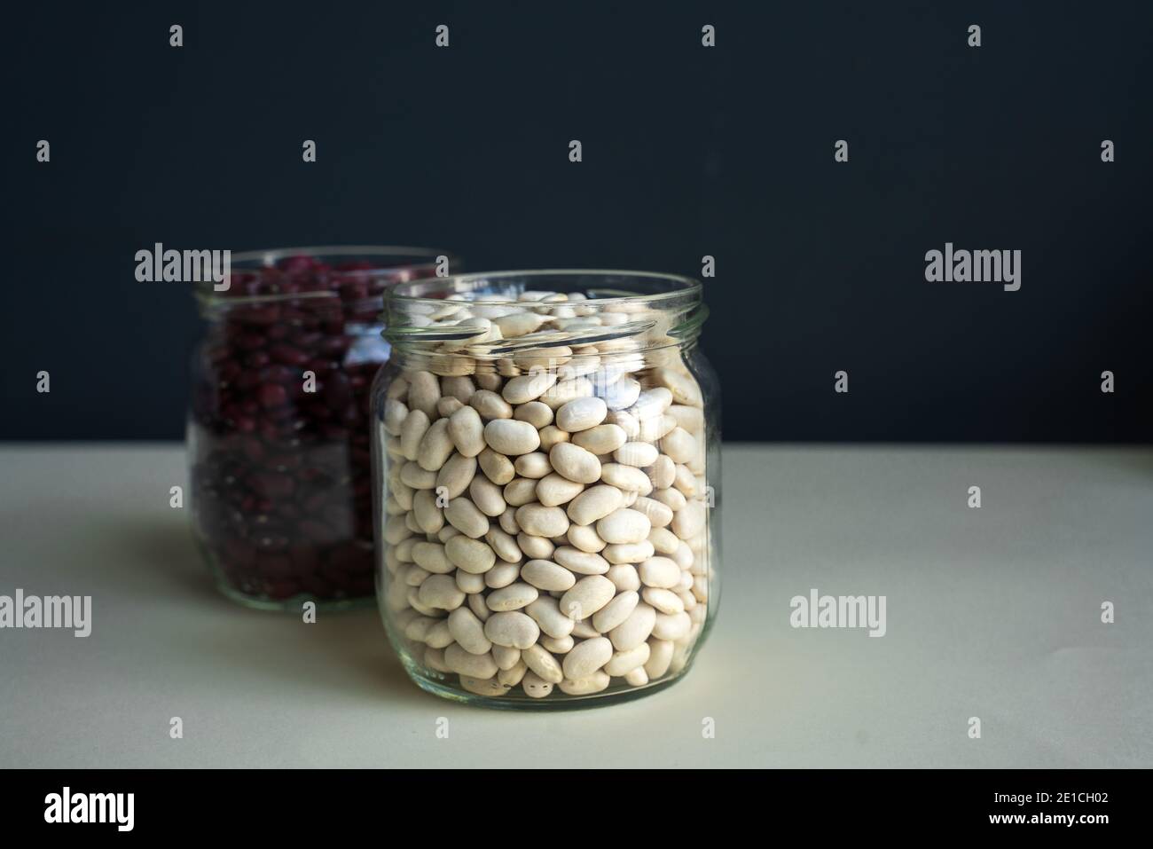 glass jar with red kidney bean and white bean. navy bean, bean, white kidney bean on white backdrop black background Stock Photo