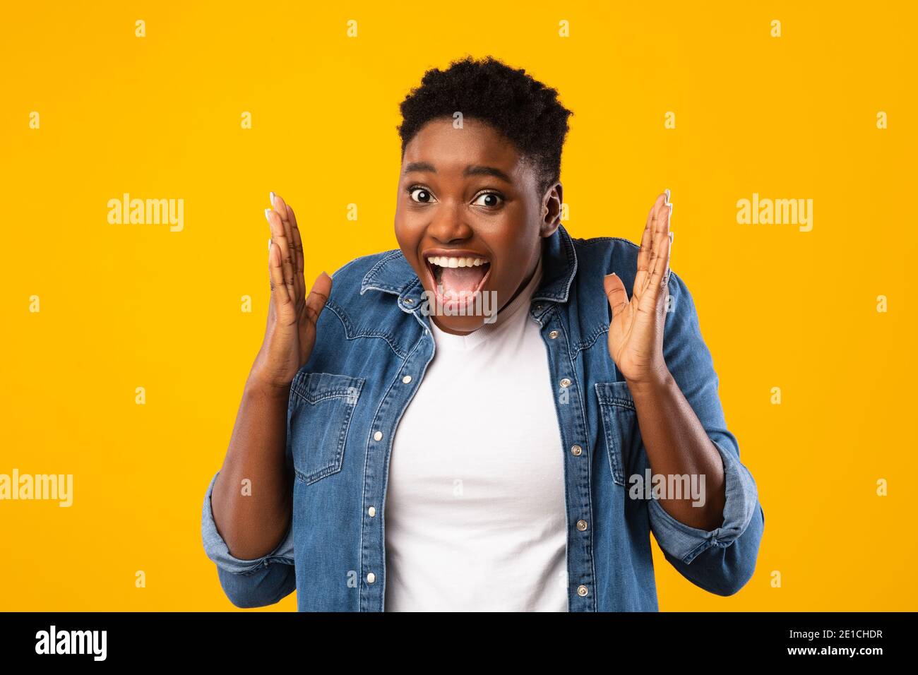 Excited African Woman Shouting In Excitement Posing Over Yellow Background Stock Photo