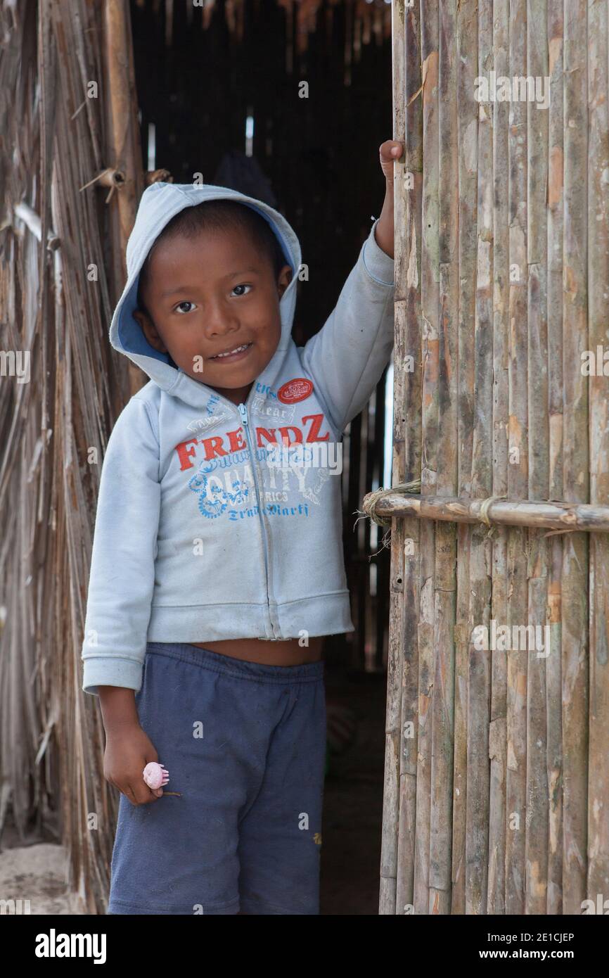 Young Kuna boy standing at the entrance of his hut on Isla Perro (Dog Island) Stock Photo