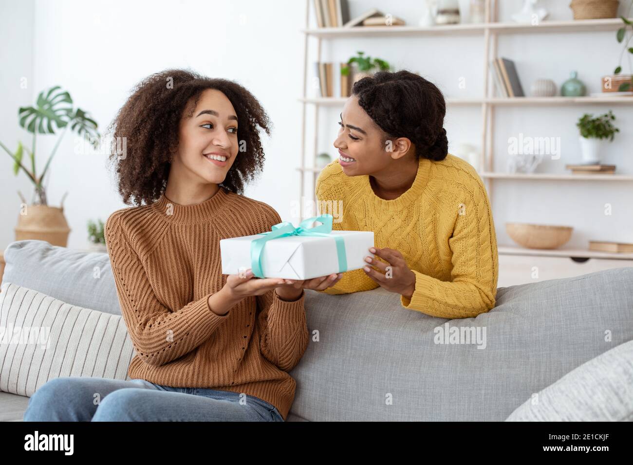 Happy sisters exchanging gifts on holiday, new year or birthday Stock Photo