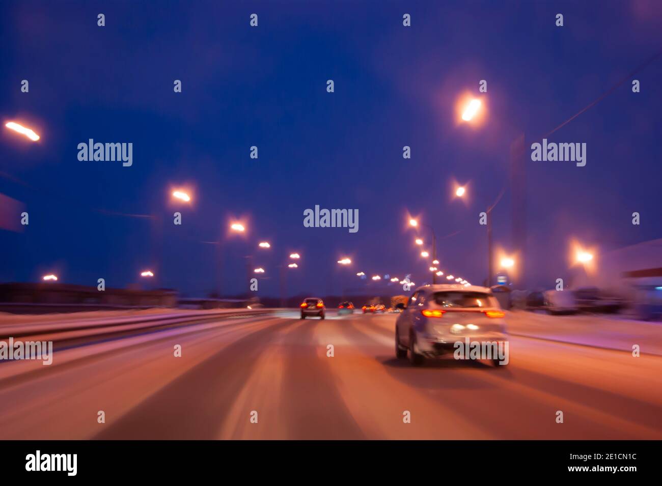 Night highway in winter. Light headlights in the dark, the movement of cars from the viewer Stock Photo