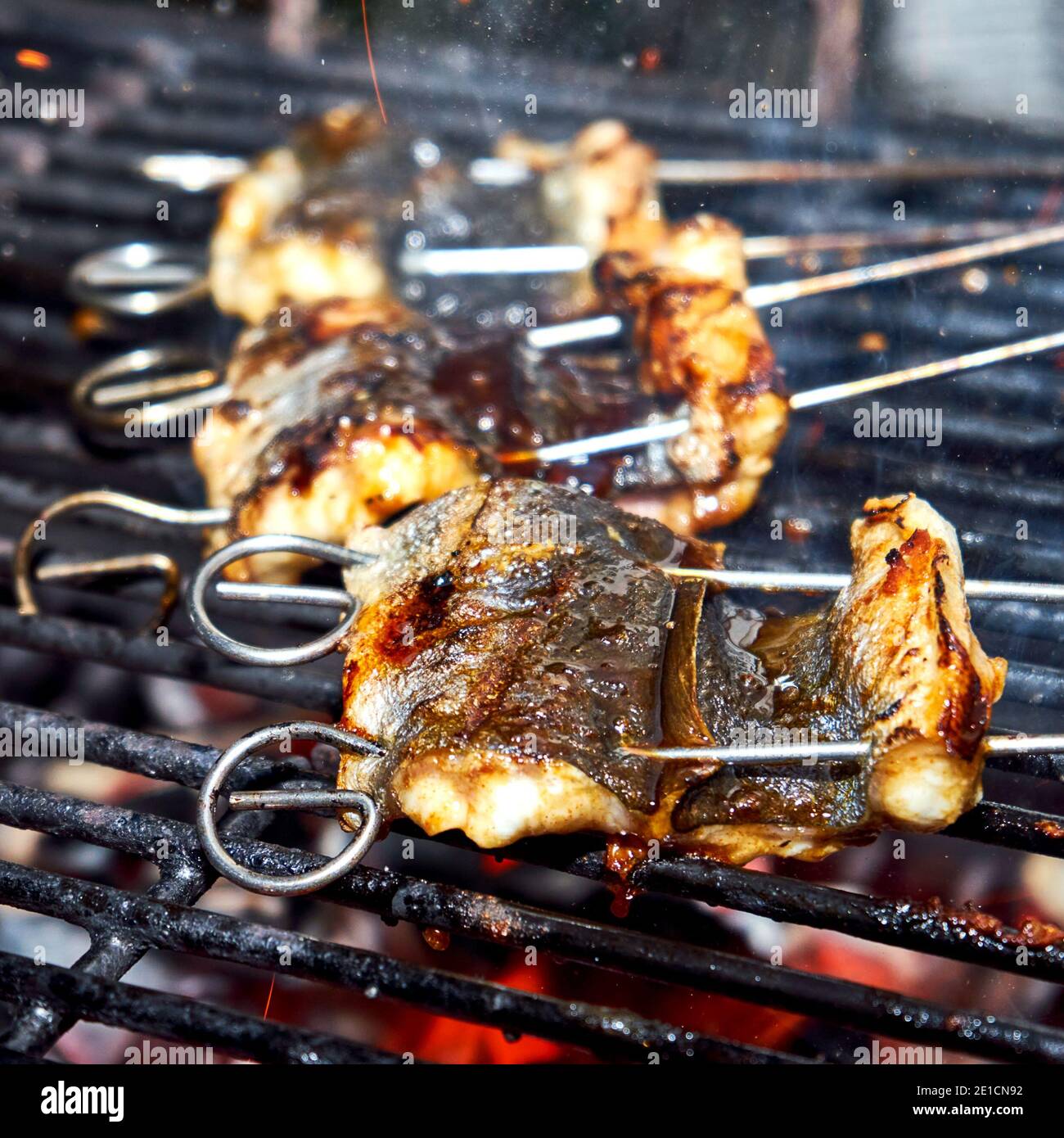 Skewered pieces of fresh Japanese marinated eel on the hot charcoal