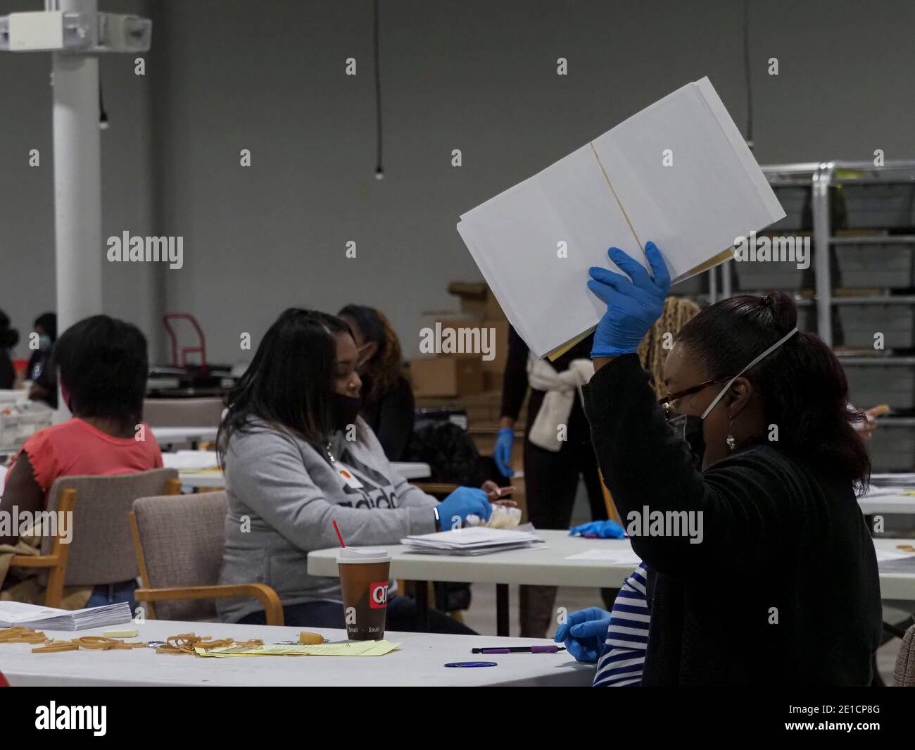 Lawrenceville, Georgia, USA. 6th Jan, 2021. An election worker raises her hand to signal that this batch of mail-in absentee ballots are ready for the next step in processing. Credit: Sue Dorfman/ZUMA Wire/Alamy Live News Stock Photo