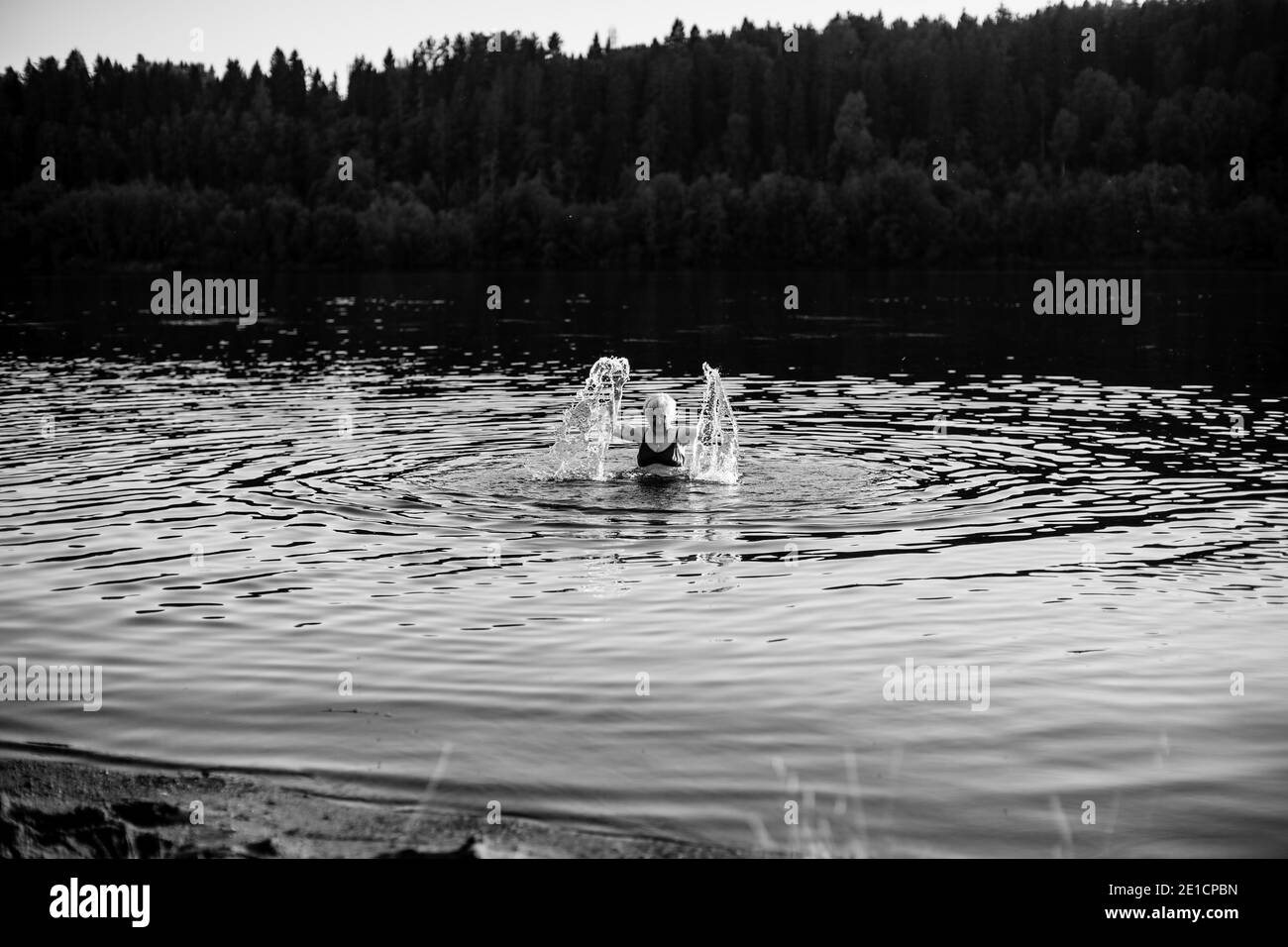 An old woman in the summer river. Black and white photo. Stock Photo