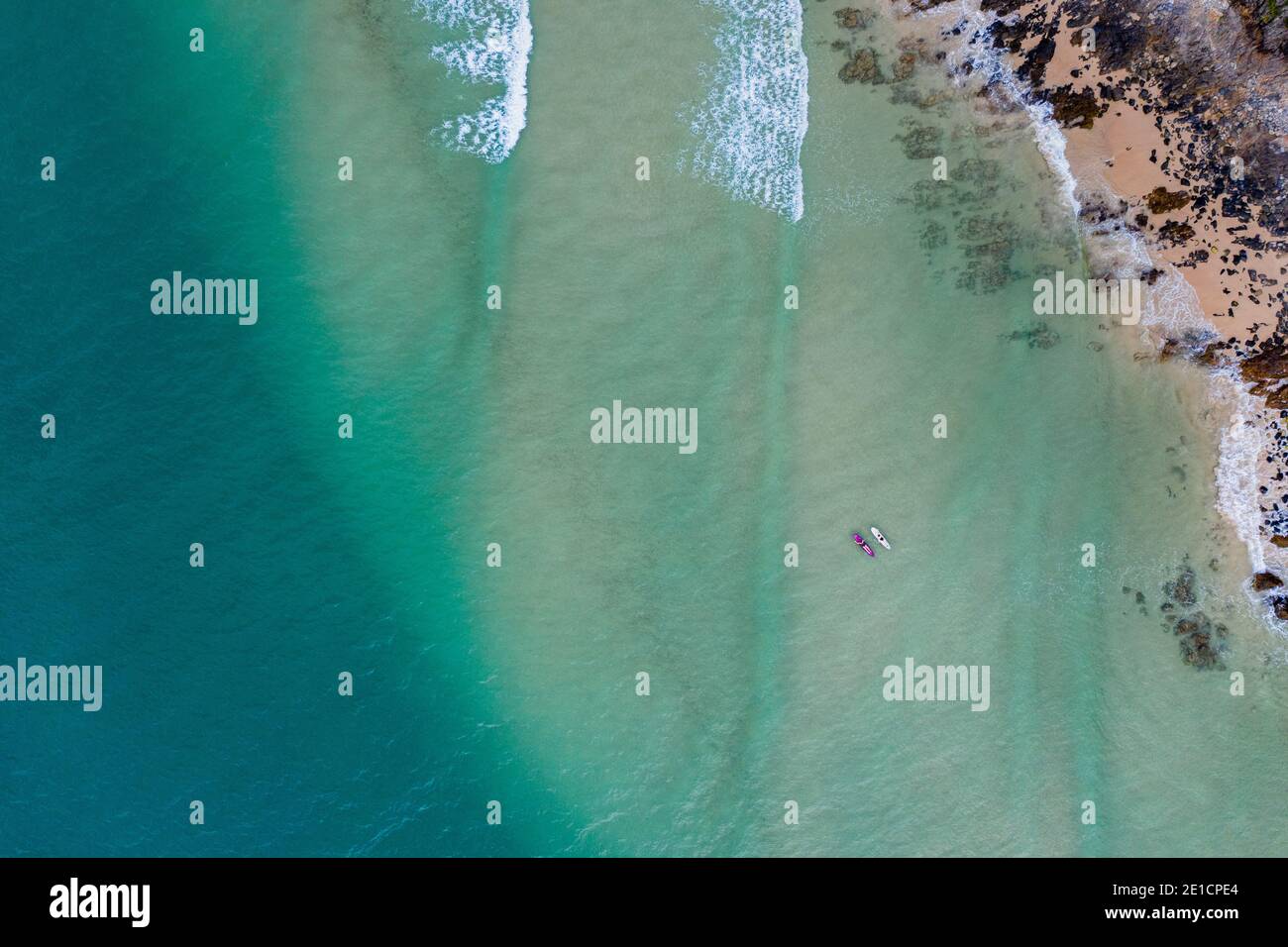 Two women are paddling their surfboards seen from above at Little Cove, Noosa Heads, Queensland, Australia Stock Photo