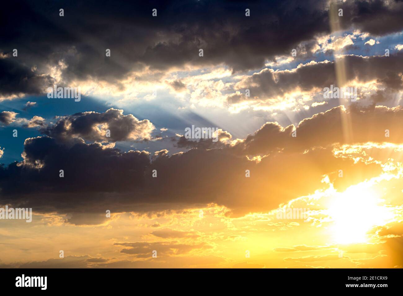 Rays of sun over the blue cloudy sky - Sunset - Sunrise Stock Photo