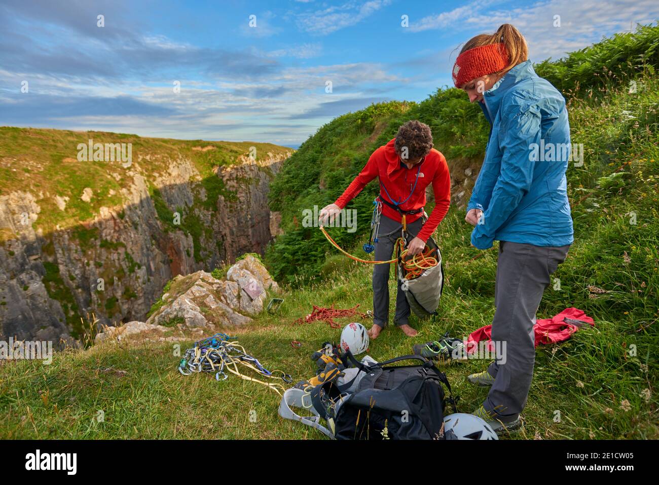 Photograph of two adventurous male and female rock climbers on top of a