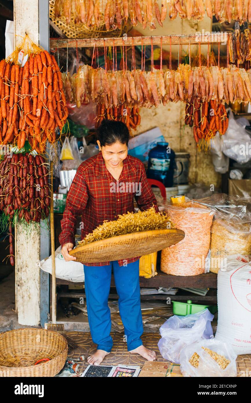 Woman drying little fish on the old market in Cambodia Stock Photo