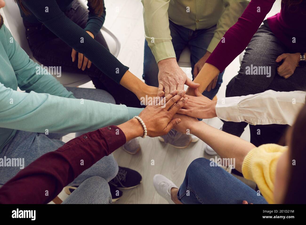 Multiracial people putting hands together in team meeting or group therapy session Stock Photo