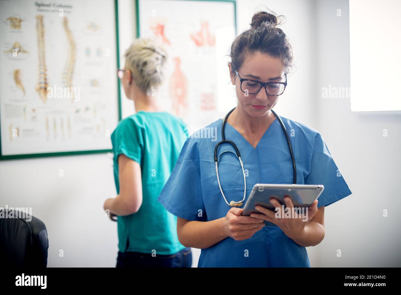 Two professional nurses in office looking through some medical