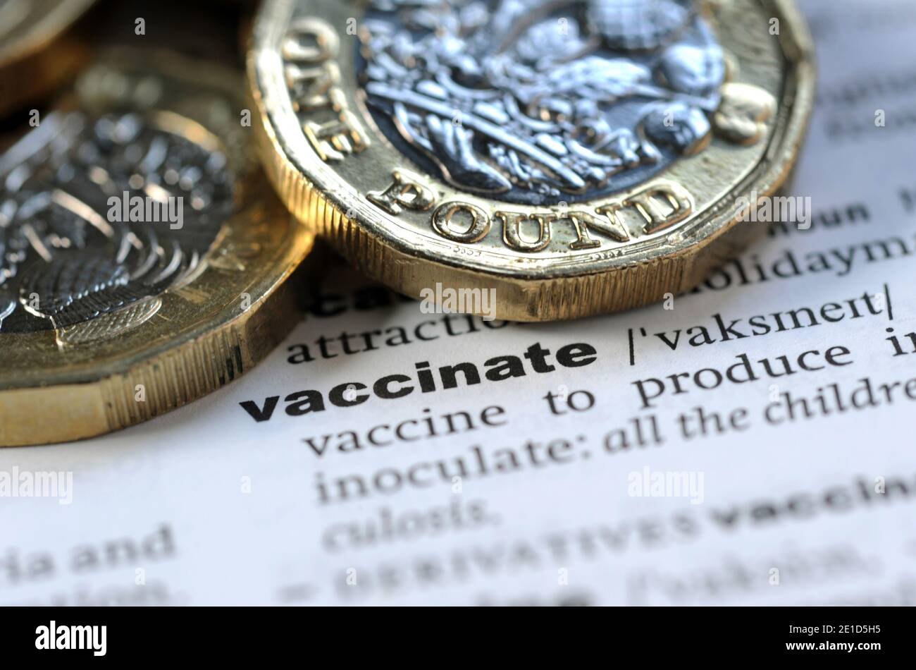 DICTIONARY DEFINITION OF VACCINATE WITH ONE POUND COINS RE COVID 19 CORONAVIRUS VIRUSES COST ETC UK Stock Photo