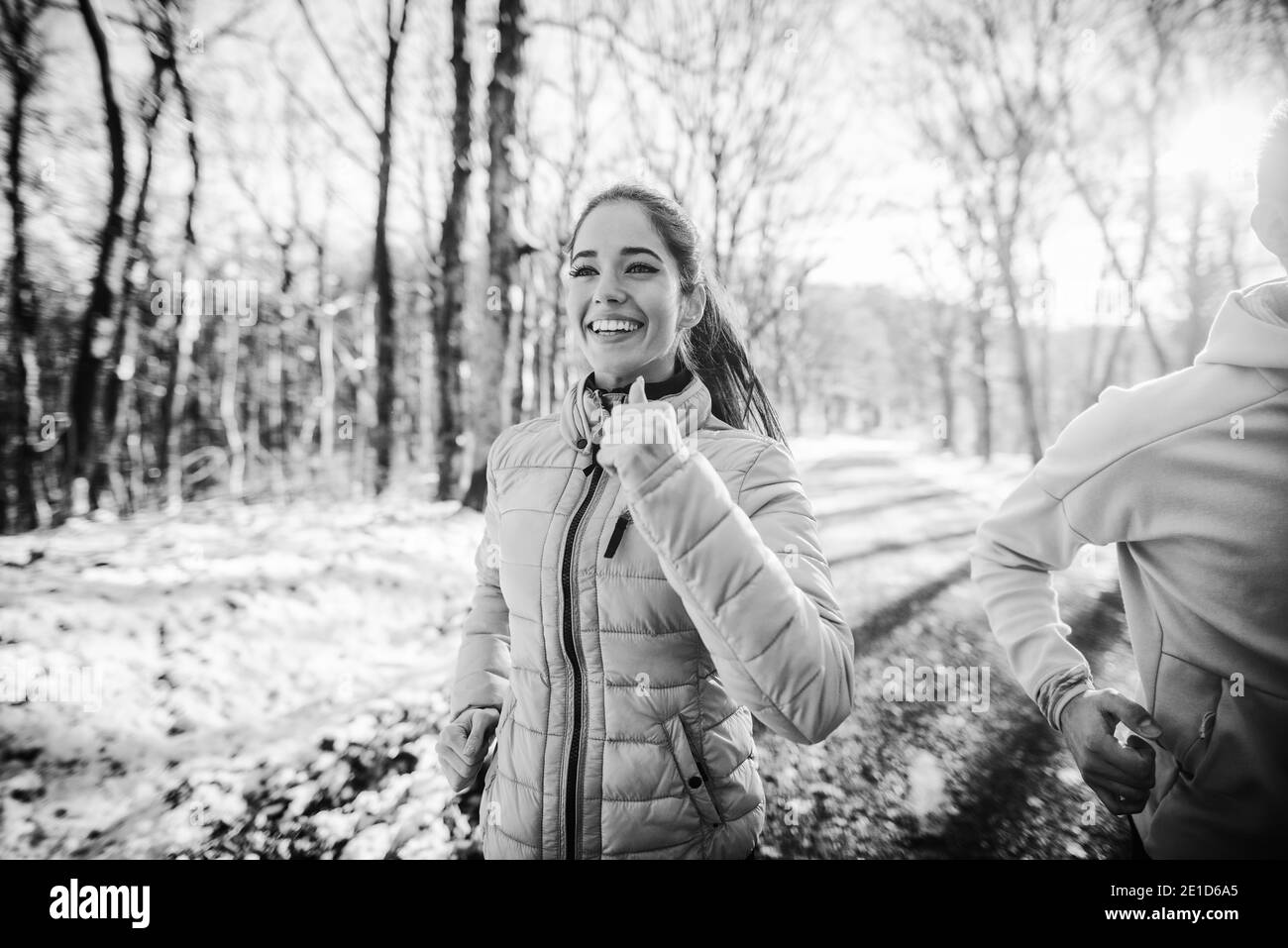 Couple running in nature in winter. Close up, black and white photo. Stock Photo