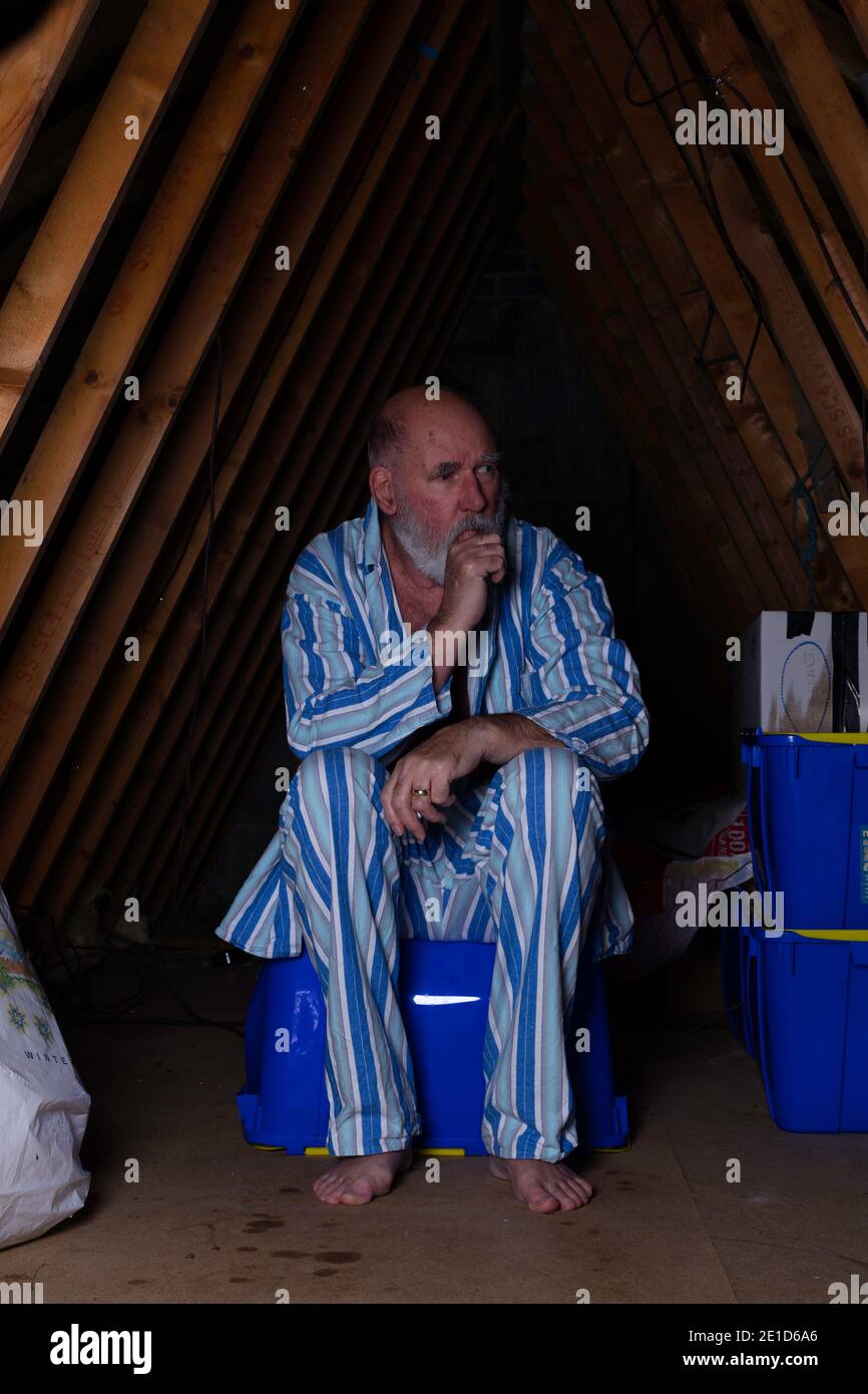 Mentally challenged senior man living in the attic. Stock Photo
