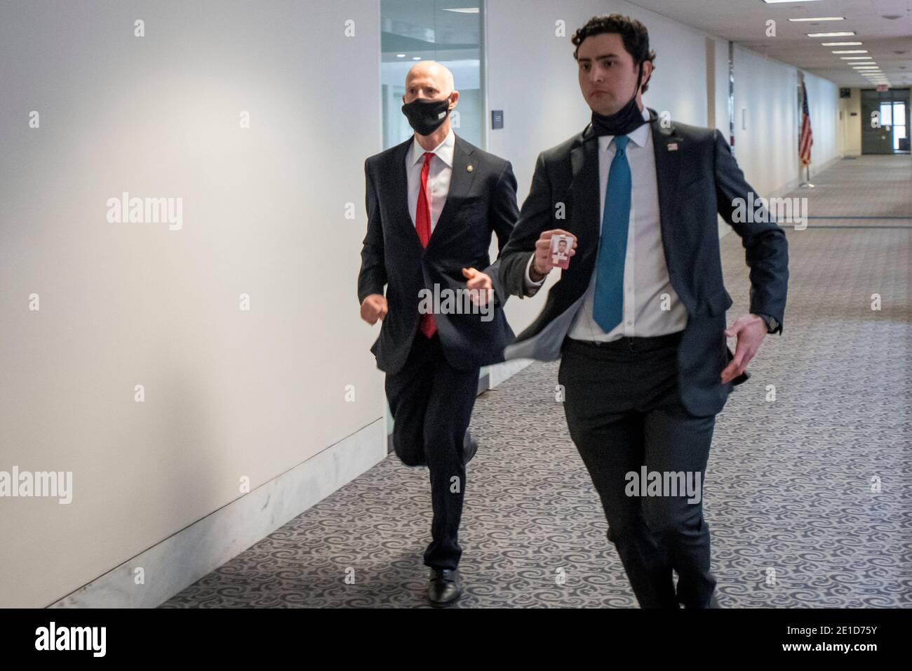 United States Senator Rick Scott (Republican of Florida), left, and a staff member and other Senators evacuate to a safe place in the Dirksen Senate Office Building after Electoral votes being counted during a joint session of the United States Congress to certify the results of the 2020 presidential election in the US House of Representatives Chamber in the US Capitol in Washington, DC on Wednesday, January 6, 2021, as interrupted as thousands of pr-Trump protestors stormed the U.S. Capitol and the House chambers. Credit: Rod Lamkey/CNP /MediaPunch Stock Photo