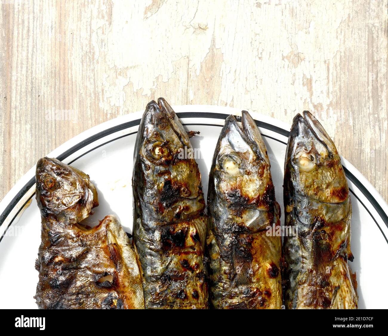 Grilled Mackerel fish on a white plate. Fatty, oily fish is an