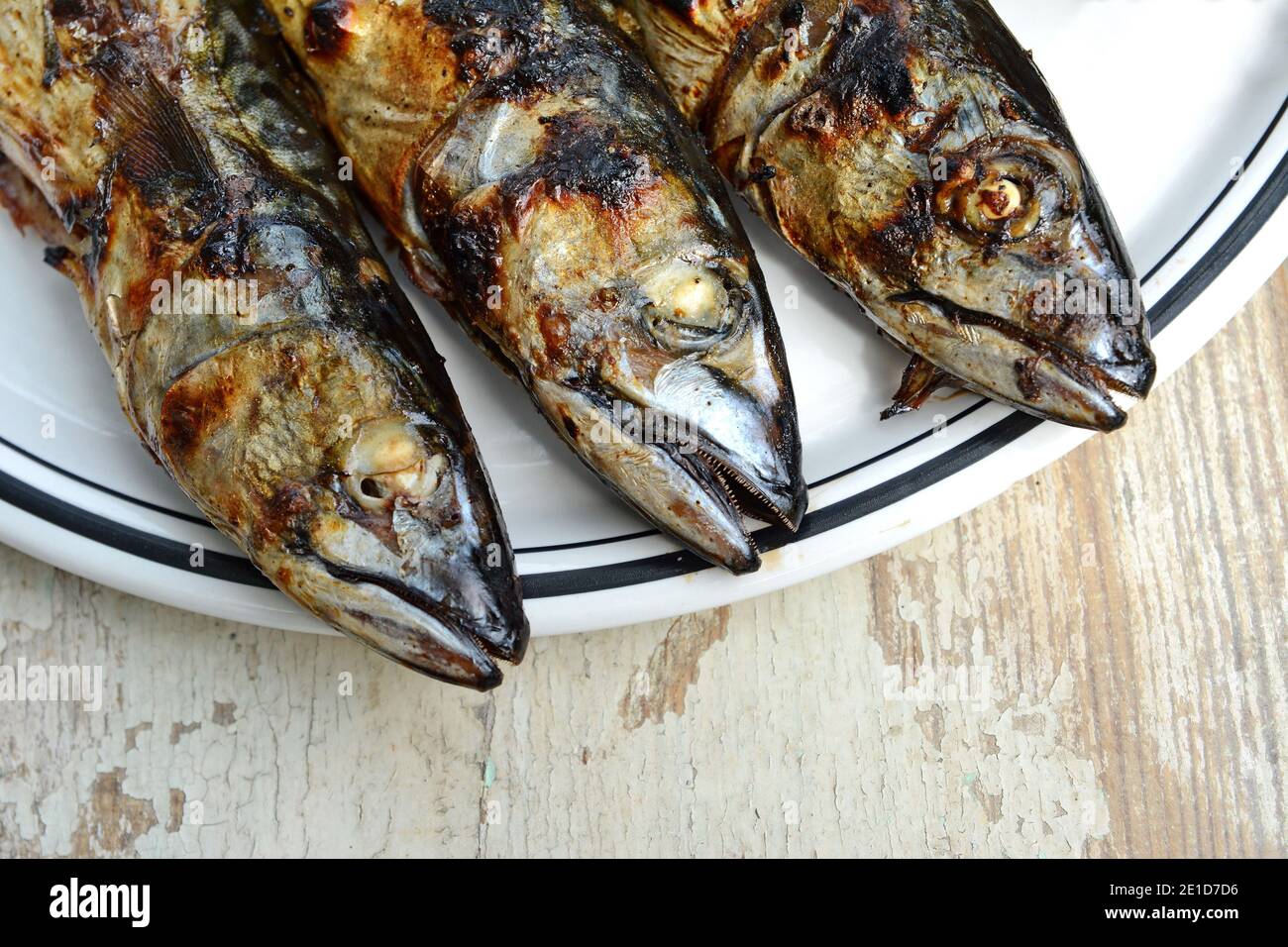Grilled Mackerel fish on a white plate. Fatty, oily fish is an