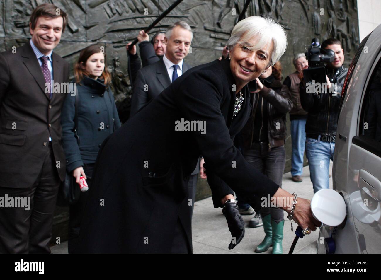 French Minister for the Economy, Finance and Industry Christine Lagarde shows how to charge the batteries of an Ion Peugeot full electric car near Peugeot Managing Director Vincent Rambaud, in Paris, France, on January 20, 2011. The Economy ministry will use the four seat four-door city ion car, launched at the end of 2010. Photo by Stephane Lemouton/ABACAPRESS.COM Stock Photo