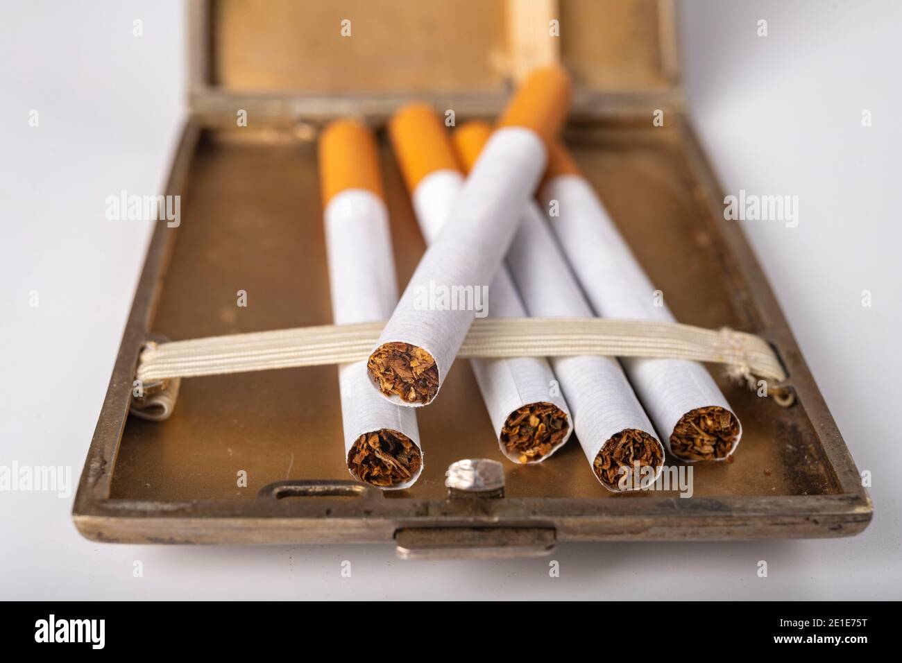 is a cigarette a stimulant Cigarettes in a metal cigarette case. Stimulants for adults dangerous to  health. Light background Stock Photo