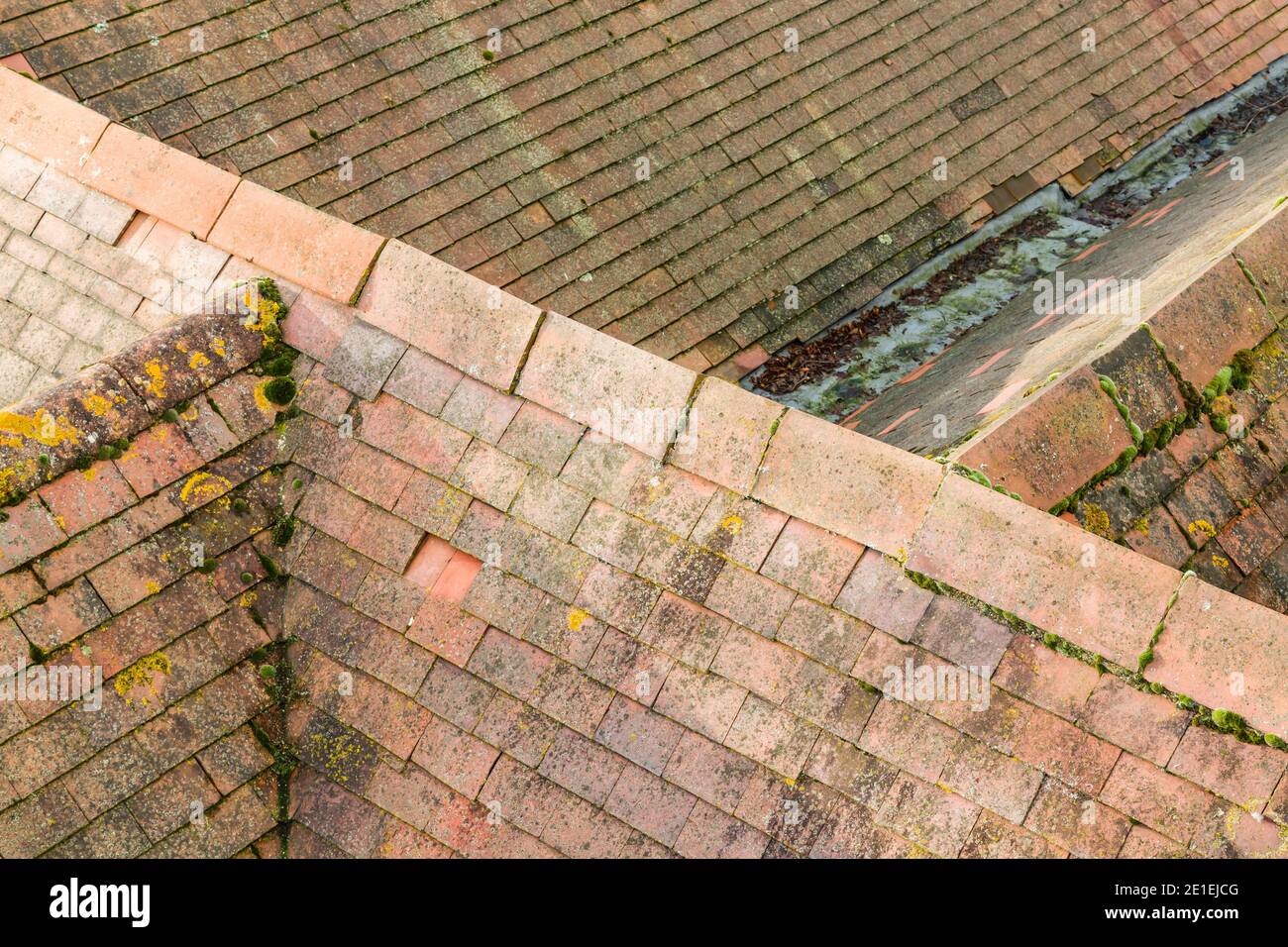 Aerial view of pitched tiled roof (rooves) on old English houses. Line of plain clay ridge tiles
