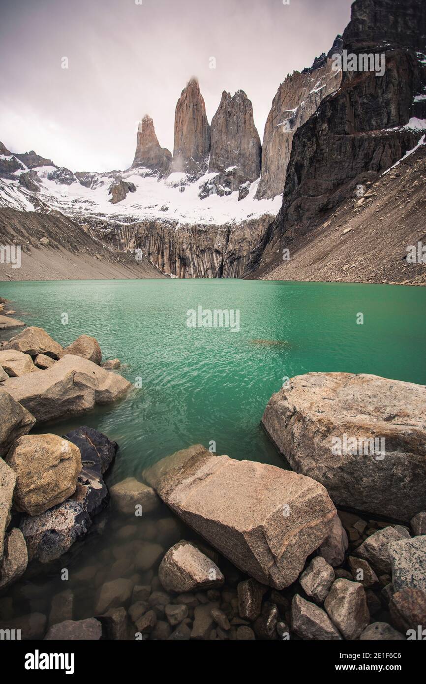 The Towers of Torres Del Paine Behind their Green Alpine Lake Stock Photo