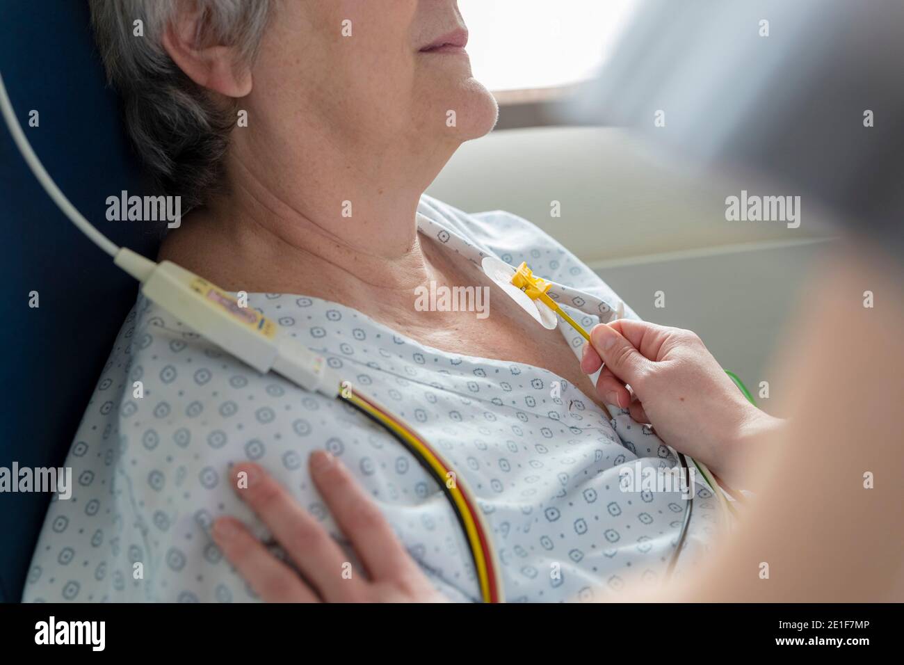 a nurse places electrodes on a patient's chest Stock Photo