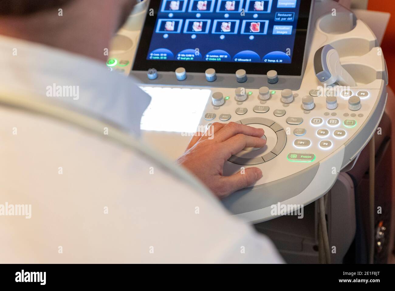 shot of a caregiver's hand, using the keyboard of an ultrasound Stock Photo