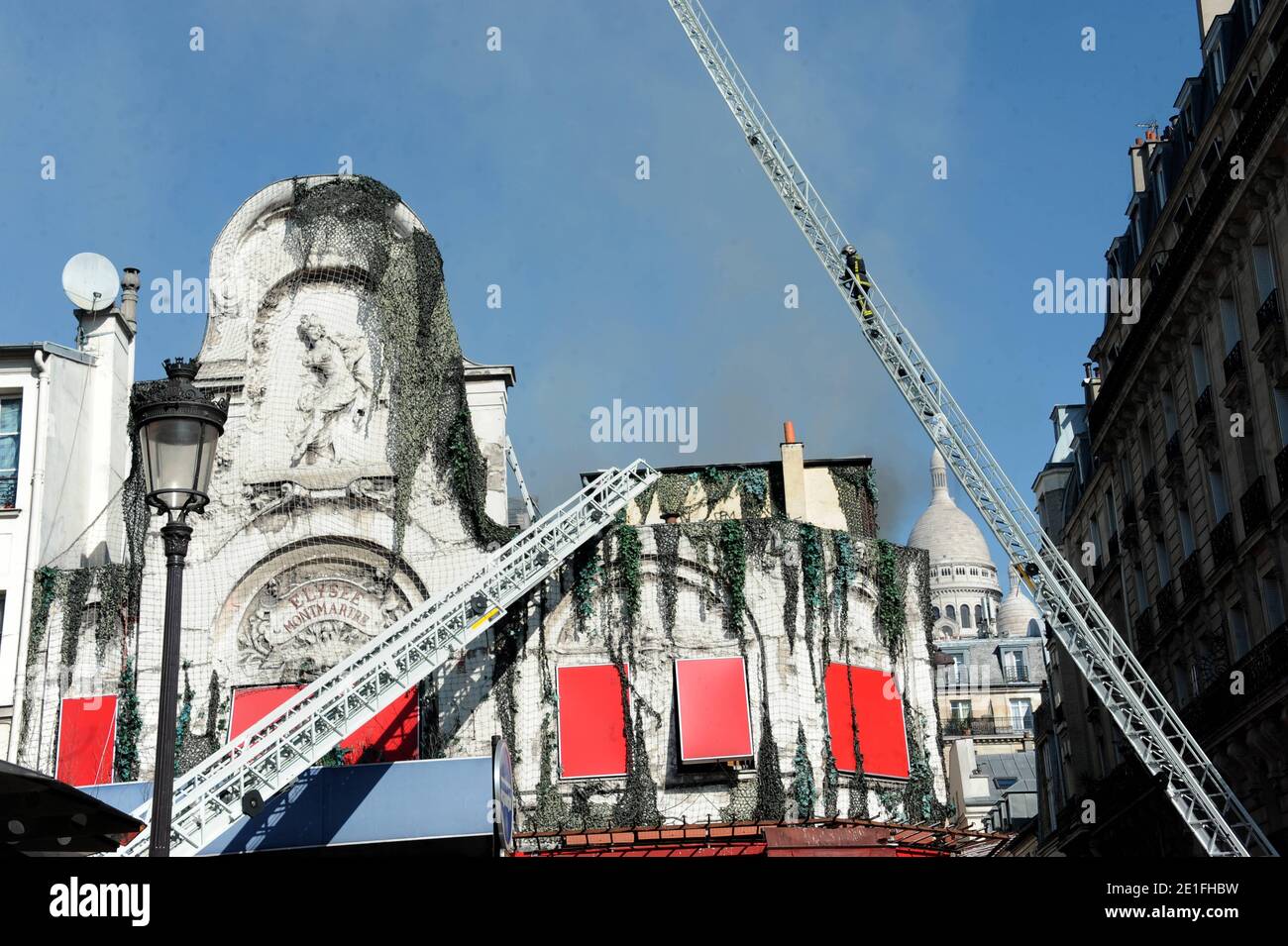 Smoke rises near the Sacre-Coeur de Montmartre basilica, in Paris, France on March 22, 2011, from the Elysee Montmartre music hall where a fire broke out this morning. The cabaret, created in the XVIIIth century, is one of the birth places of famous French Cancan. Photo by ABACAPRESS.COM Stock Photo