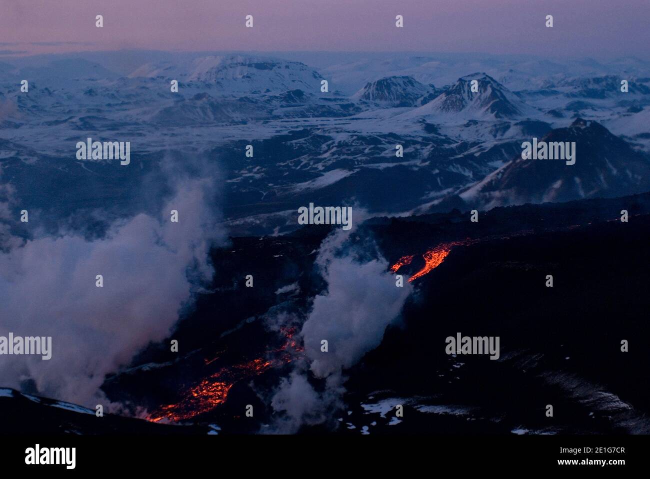View of lava from Eyjafjallajokull volcano, flowing down newly-built cinder cone, sihouetted against sunset, Southern Iceland | NONE | Stock Photo