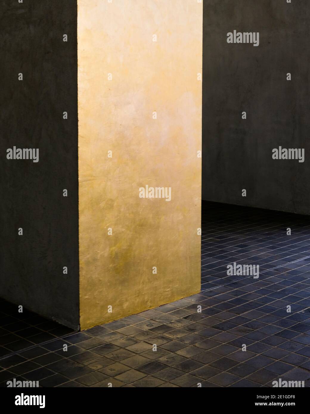 Detail of black mosaic floor tiles and golden pillar, Fondazione Prada, Milan, Italy. Stock Photo