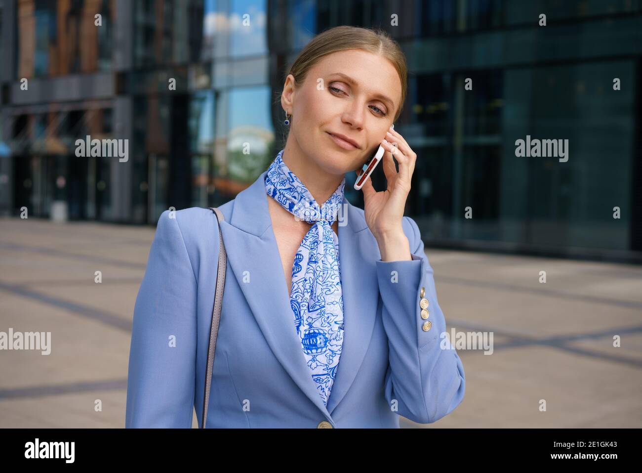 Strict Jacket A blonde business woman dressed in a strict jacket is talking on the ...