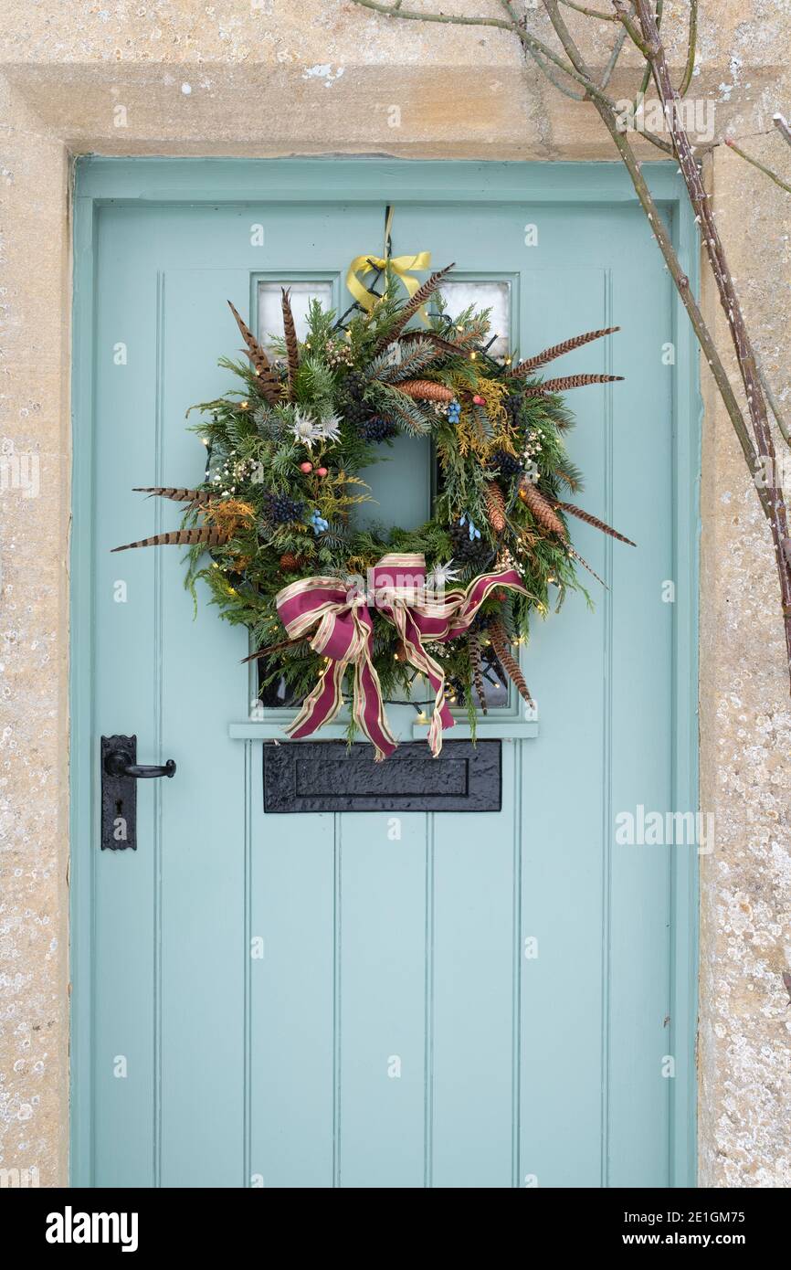 Christmas wreath on a cottage door in the snow. Taynton, Cotswolds