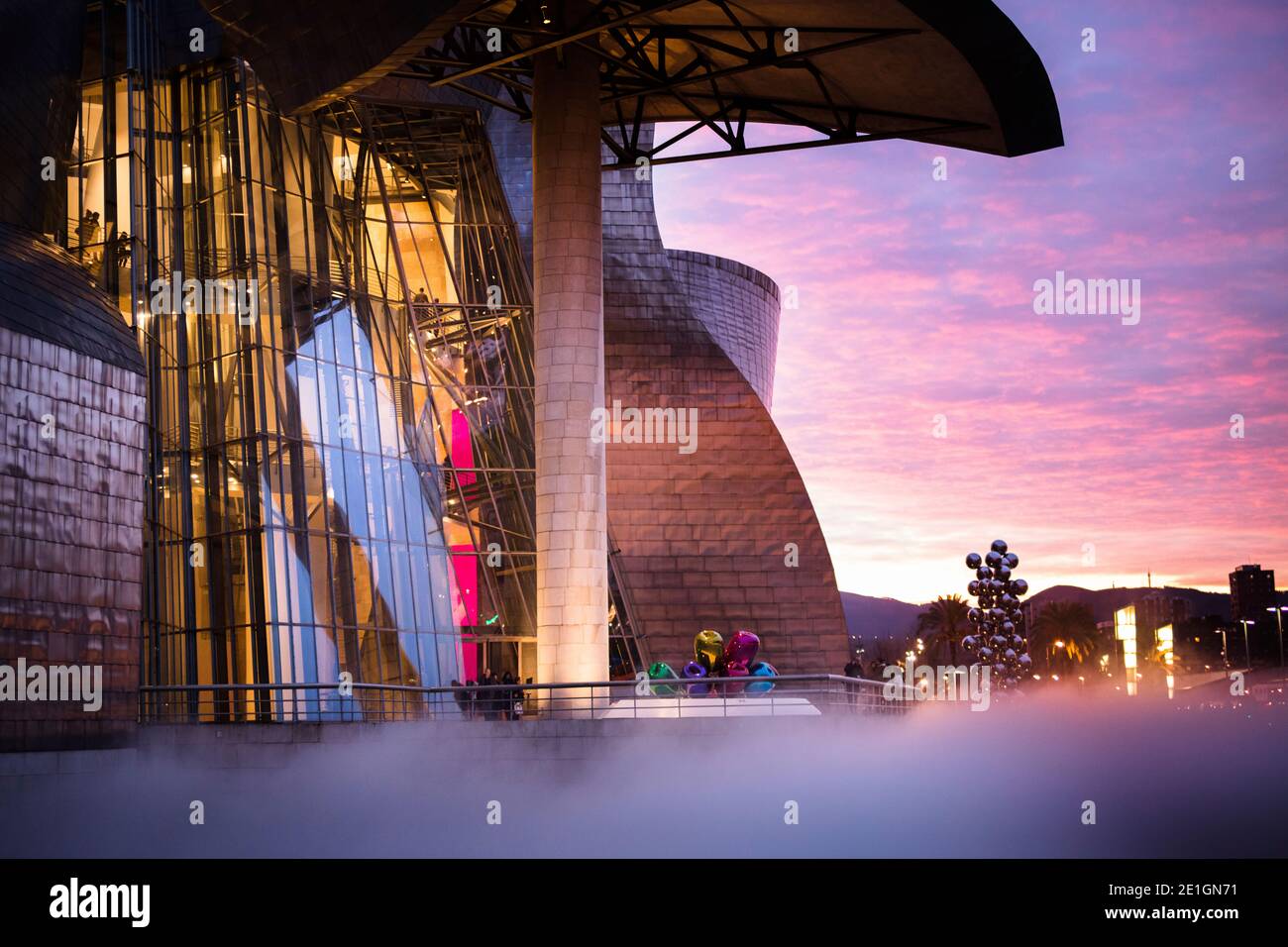 Exterior view of the curved titanium and glass facade of The Guggenheim Museum in Bilbao, Basque Country, Spain at sunset. Stock Photo