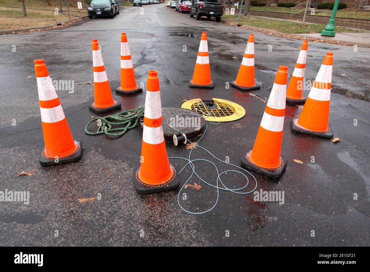 Orange cones protecting traffic from drain in street. St Paul Minnesota MN USA Stock Photo