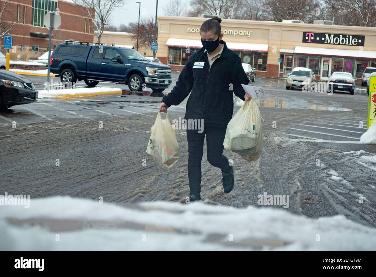 Masked worker bringing curbside groceries to a car from Lunds Byerlys Grocery Store during the Covid Pandemic. St Paul Minnesota MN USA Stock Photo