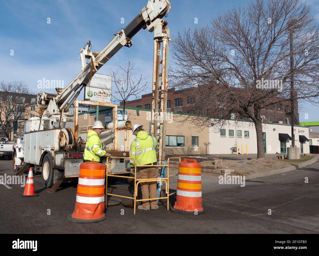 Men with power driver on a truck repairing sewer under a city street. St Paul Minnesota MN USA Stock Photo