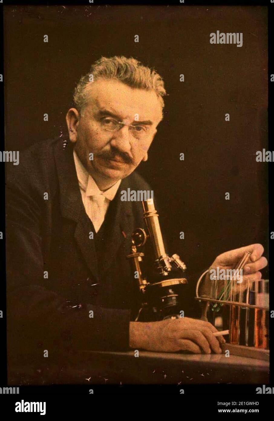 Louis Lumiere with microscope and test tubes. Stock Photo