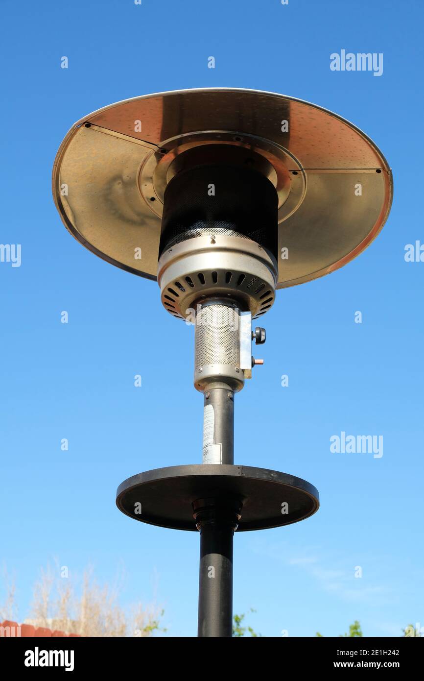 Outdoor patio gas heater in a backyard in the day time with a blue sky backdrop. Stock Photo