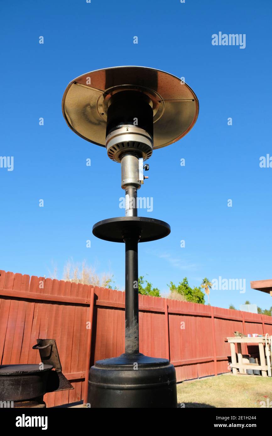 Outdoor patio gas heater in a backyard in the day time with a blue sky backdrop. Stock Photo