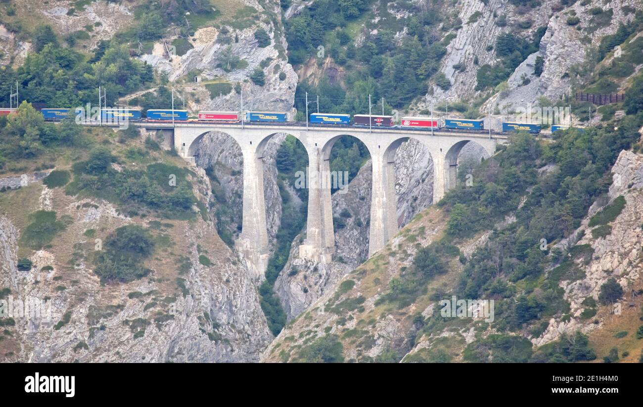Raron, Switzerland on july 16, 2020: Train going over old stone viaduct in the Swiss mountains Stock Photo
