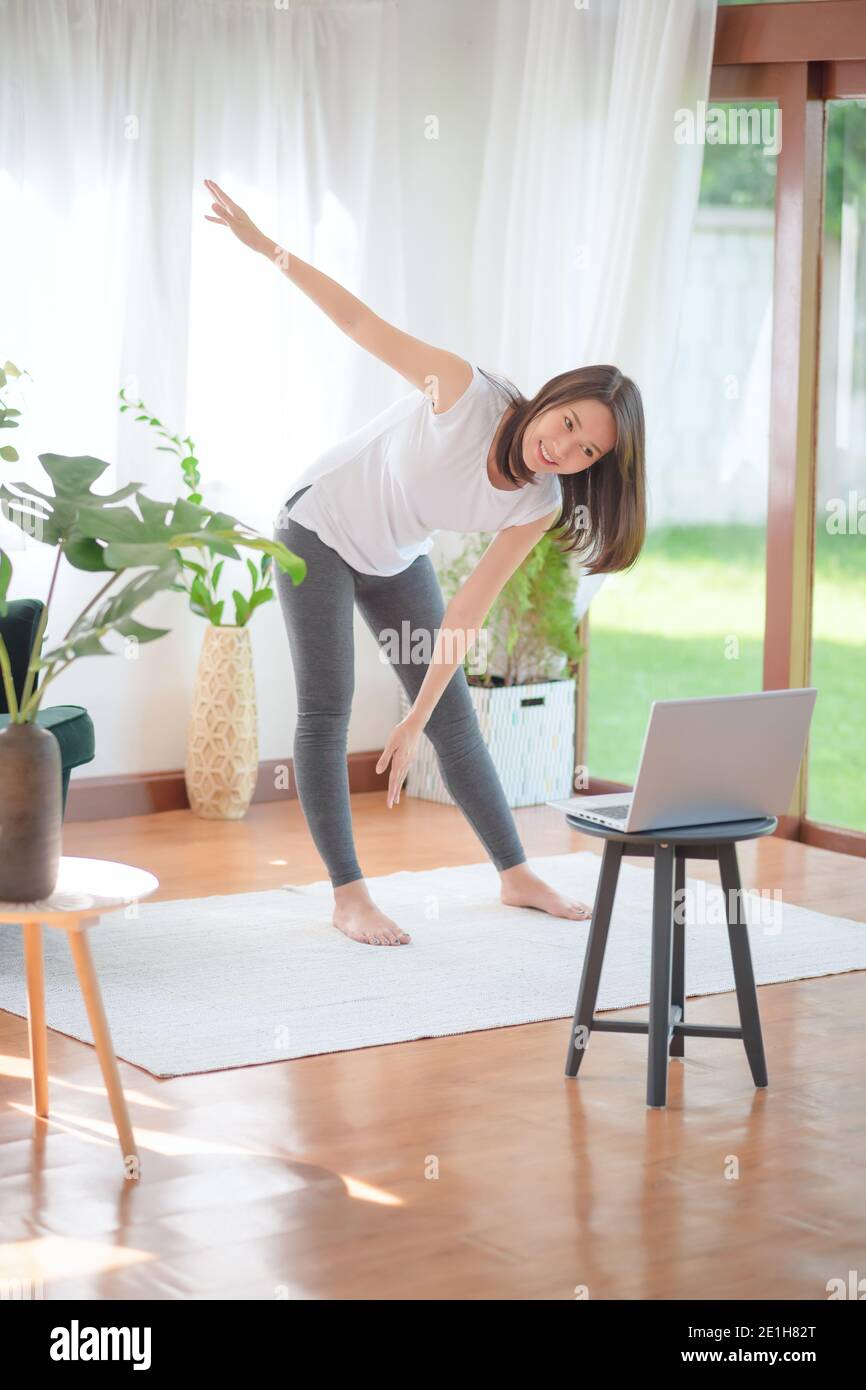 Beautiful asian woman staying fit by exercising at home for healthy trend lifestyle Stock Photo