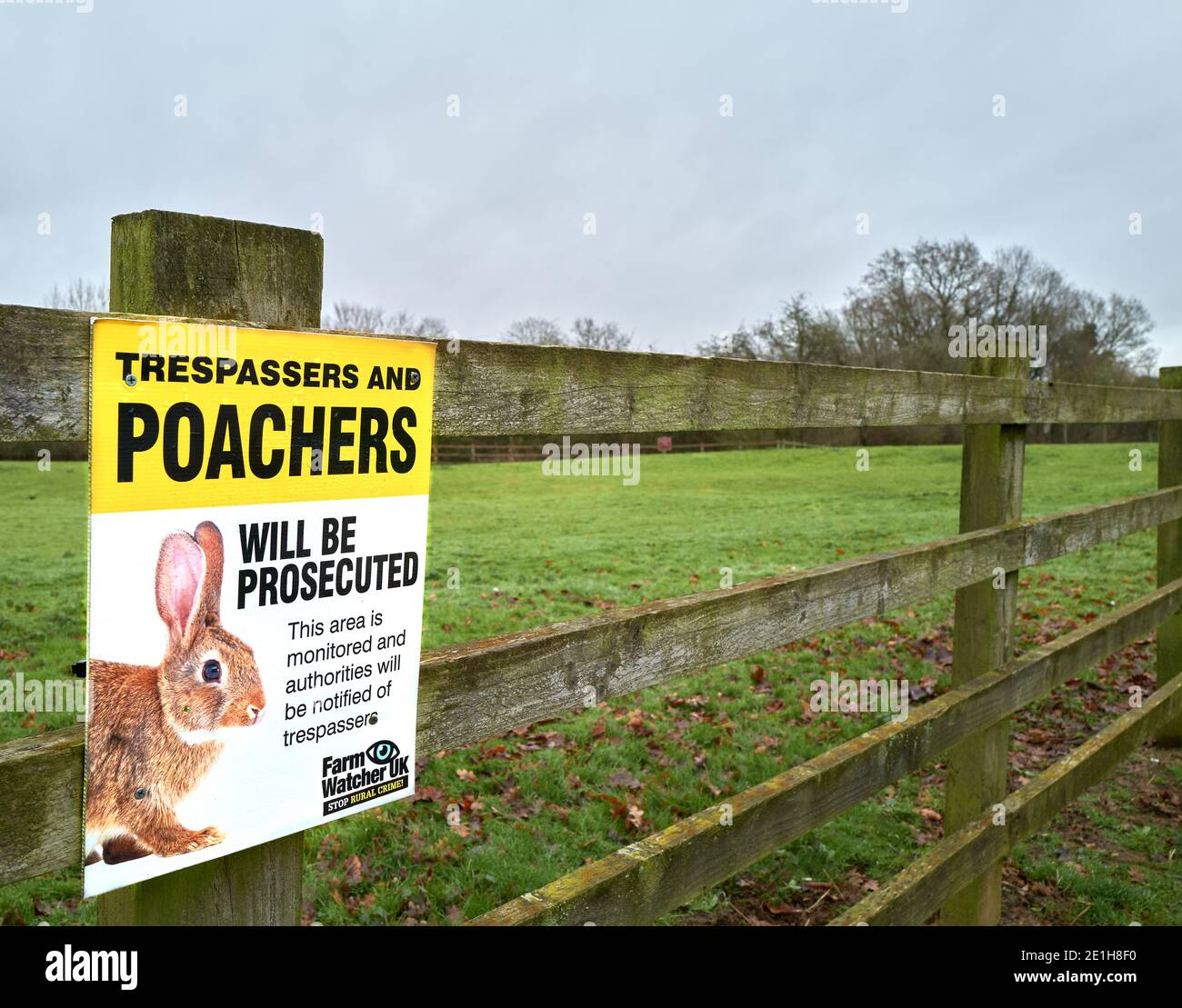 'Trespassers and poachers will be prosecuted' notice on a fence bordering a meadow at Kettering, Nhants, England. Stock Photo