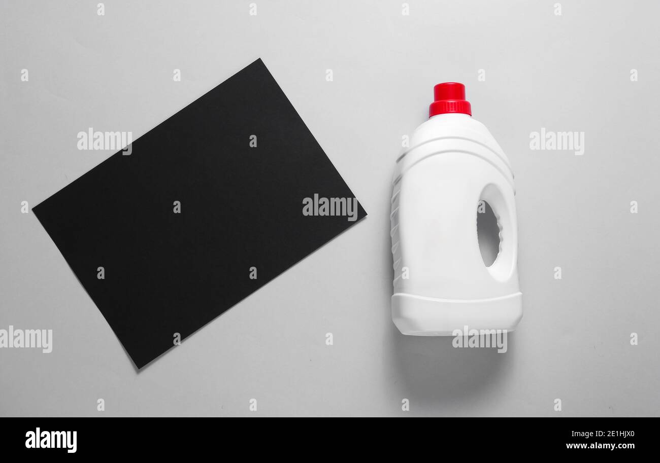 Minimalistic concept of washing. Black paper sheet for copy space, bottle of washing gel on gray background. Top view Stock Photo